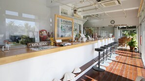 A bar area with a wooden counter, stools, and a sign reading "Nata Beach Villa".