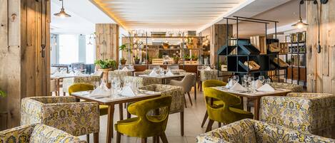 A restaurant interior with patterned furniture, wooden accents, and hanging lights.