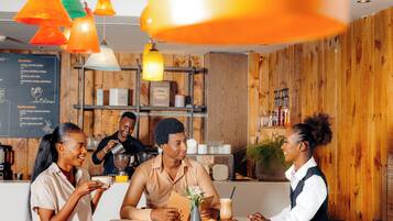 A café with wooden walls, a menu board, and a variety of coffee and food items on the counter.