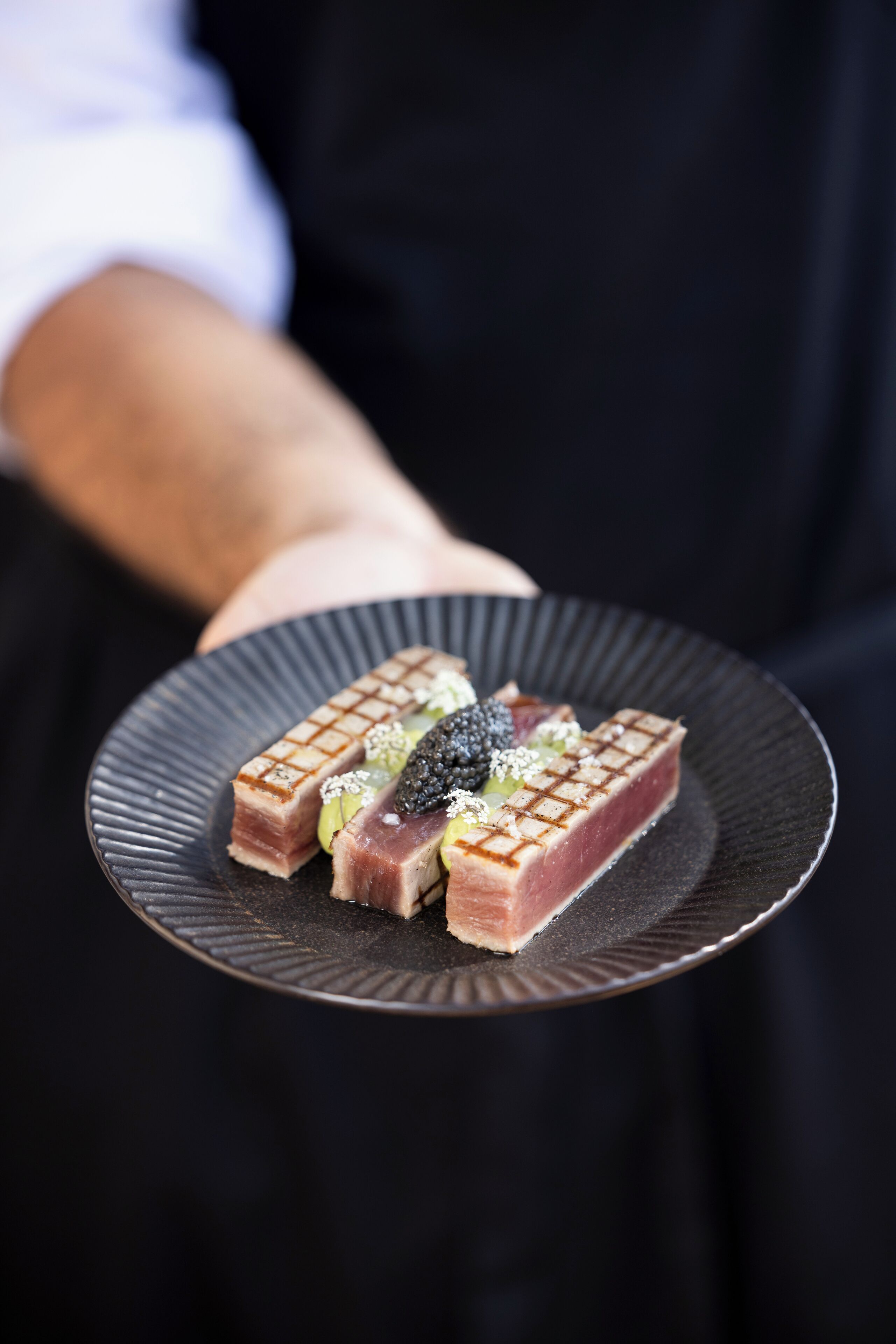 A person holding a plate with a dessert.