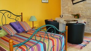 A room with a bed, a lamp, a chair, and a stone wall. - Du coq à l'âne (Saint-Georges-de-Rex)