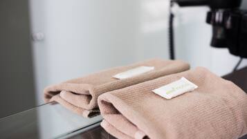 Two folded towels with a tag on a glass table.