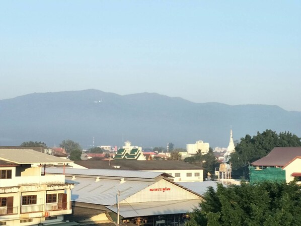 Un pueblo con edificios, incluyendo una estructura blanca con un letrero rojo y un edificio parecido a un pagodas con una aguja.