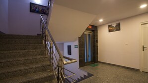 A staircase with a handrail, a door with a sign, and a wall-mounted picture.