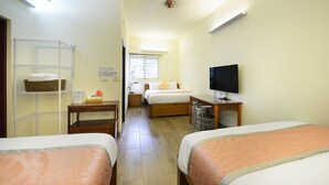 A hotel room with two beds, a television, a desk, a chair, a shelf with towels, and a window. - Yue Mei B&B (Shoufeng)