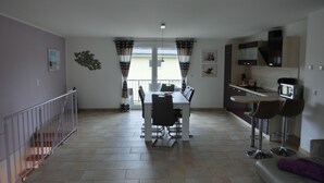 Un appartement moderne comprenant un coin repas, une cuisine et un espace de vie.