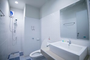 A modern bathroom with a shower, toilet, and sink. - PJ Loft Hotel (Lop Buri)