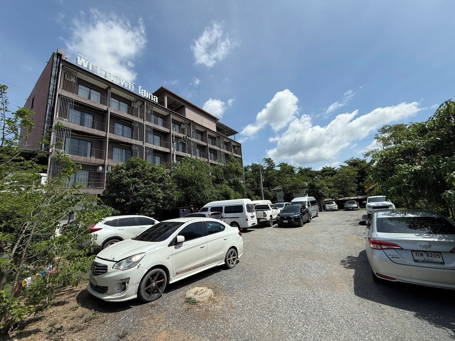 A multi-story building with a parking lot in front.