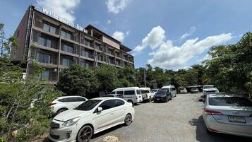 A multi-story building with a parking lot in front.
