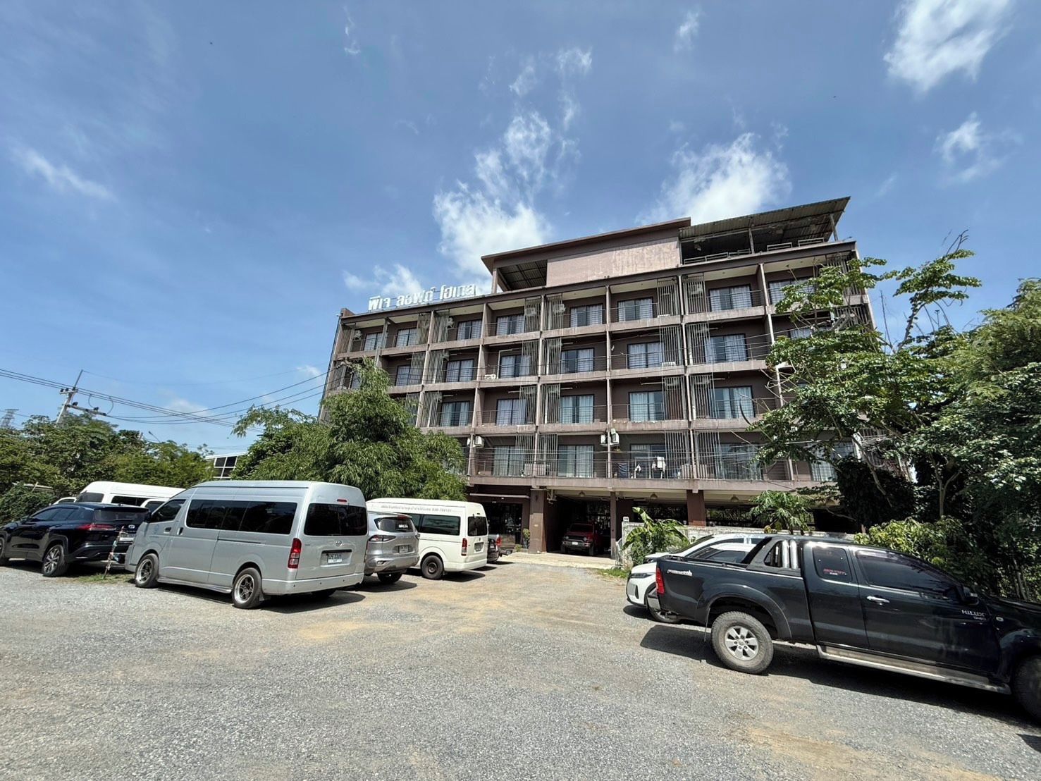 A multi-story building with a parking lot in front.