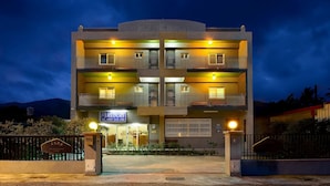 A multi-story building with balconies, a visible entrance, and a signboard with contact information. - Mei Cun B&B (Shoufeng)