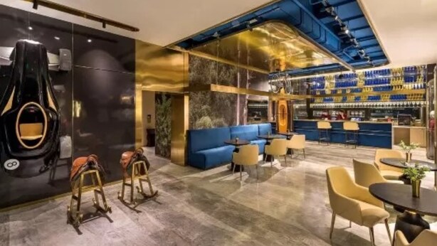 A modern bar area with a curved ceiling, seating arrangements, and a bar counter. - Manxin Hotel Xian North Railway Station Municipal Government (Xi'an)