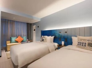 Ein Hotelzimmer mit zwei Betten, einem Schlafsofa und einem kleinen Tisch.