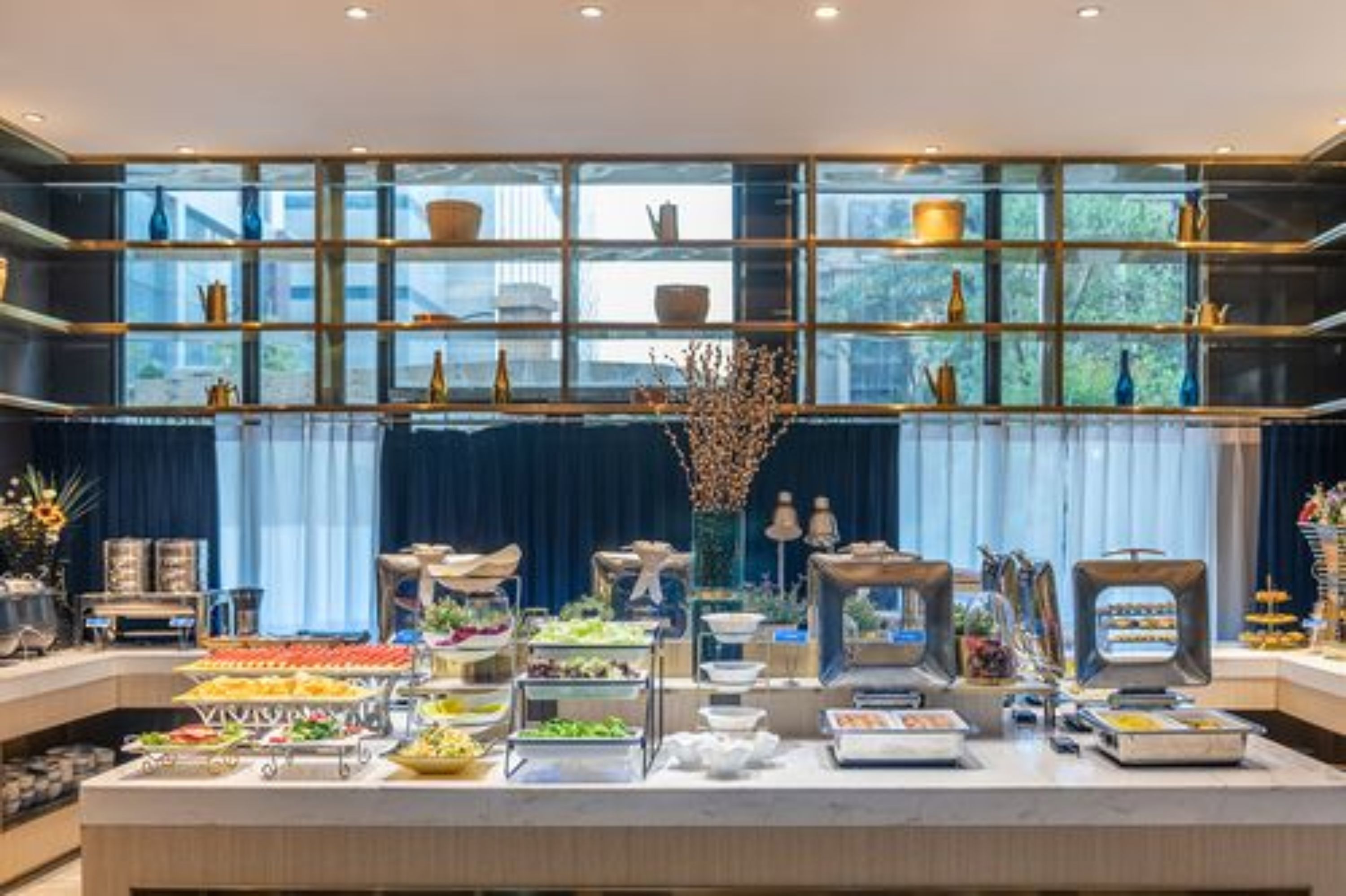A buffet setup with various food items and a decorative centerpiece.
