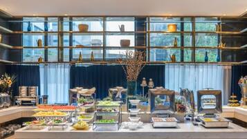 A buffet setup with various food items and a decorative centerpiece.