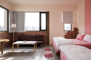 A hotel room with a brick wall, a sofa, a bed, a table, and a window with curtains. - Spring Villa (Magong)