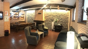 Un intérieur chaleureux avec un mur en pierre, des meubles en bois et une cheminée.