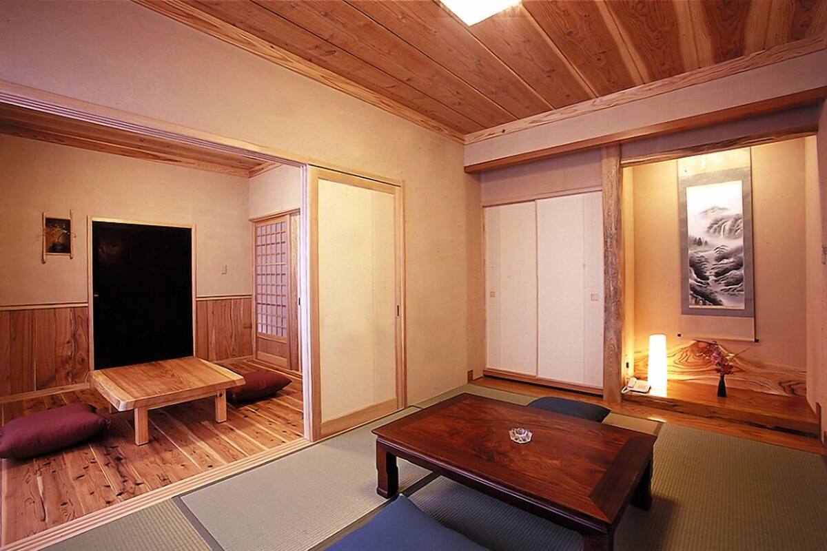 A traditional Japanese room with tatami flooring, a low wooden table, and sliding doors.