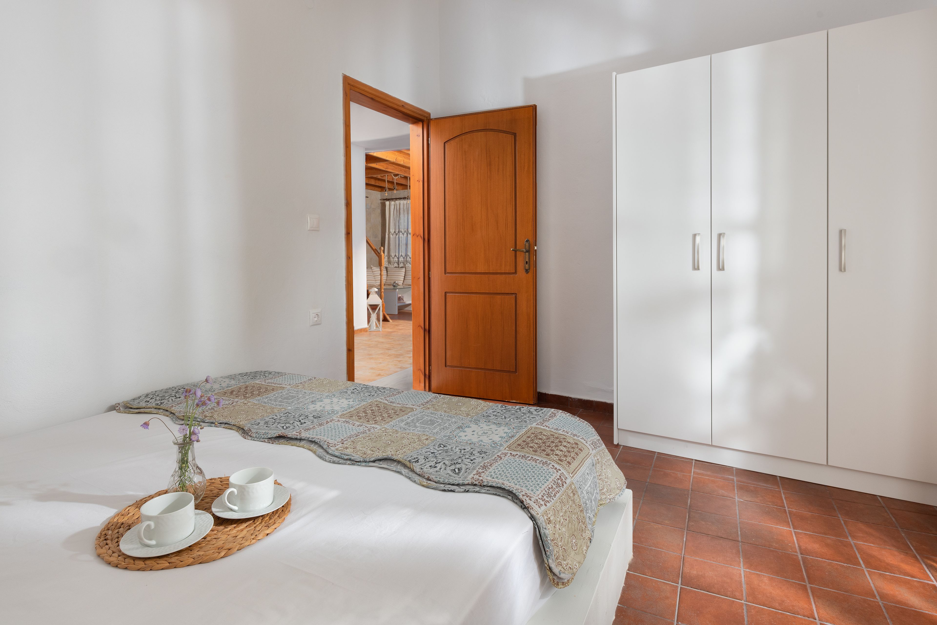 Ein Schlafzimmer mit einem Bett, einer Holztür und einem Kleiderschrank.