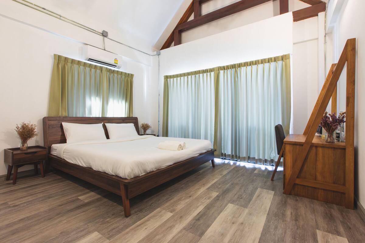 A bedroom with a wooden bed, a desk, and a chair.