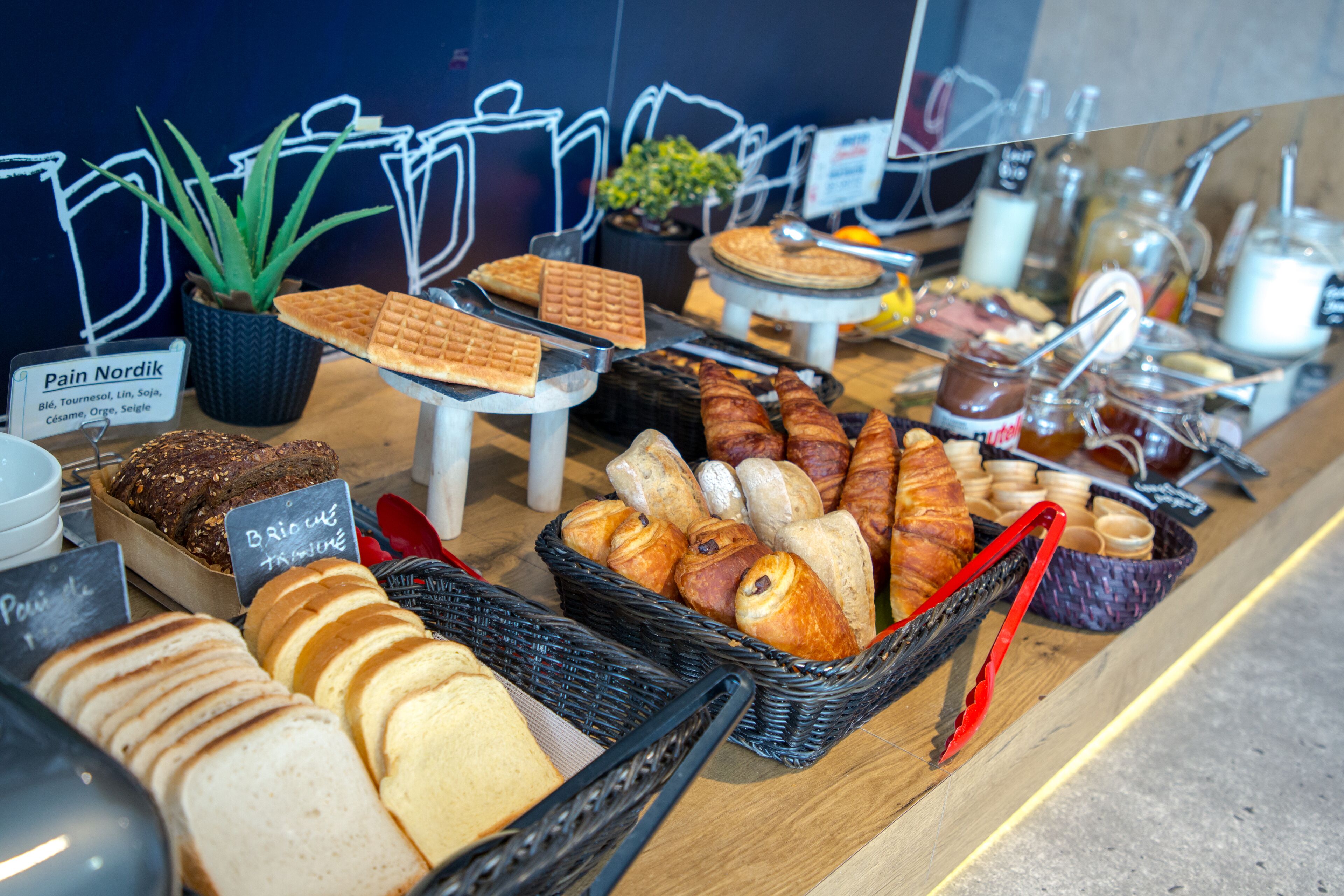 Une vitrine de boulangerie présentant une variété de pains et de pâtisseries.