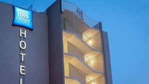 A hotel with a sign reading "ibis budget HOTEL" and a modern design with vertical lines. - ibis budget Fréjus Saint-Raphaël Centre et Plage (Fréjus)