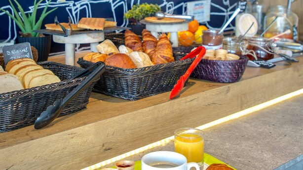 A breakfast buffet with bread, pastries, and beverages. - ibis budget Fréjus Saint-Raphaël Centre et Plage (Fréjus)