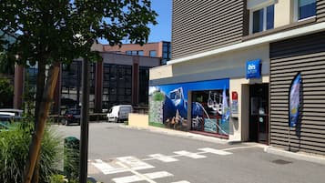 Een modern gebouw met een groot muurdecoratie van een berglandschap op de gevel.