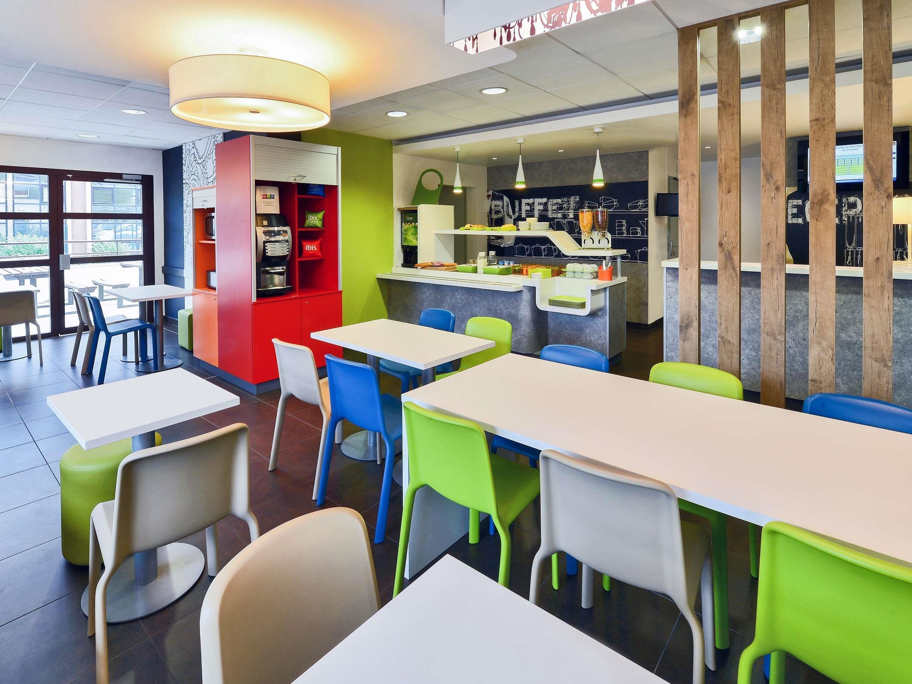 A restaurant with tables and chairs, a counter with a menu, and a window with a view.