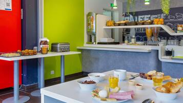 Un bufé de desayuno con diferentes opciones de comida y una estación de café.