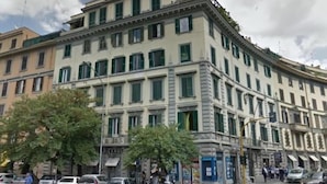 A multi-story building with a classical architectural style, featuring a central courtyard and a mix of residential and commercial spaces. - King Plaza (Rome)