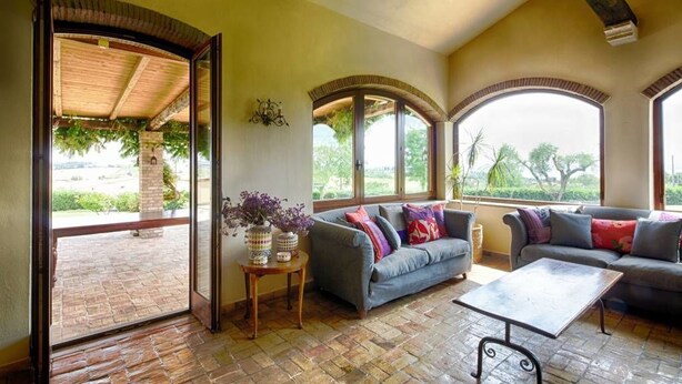 A spacious living area with a large window, a sofa, a coffee table, and a decorative vase. - La Cavetta Country House (Trevignano Romano)