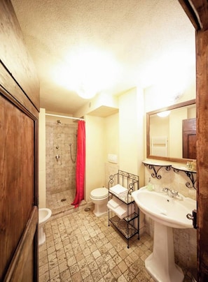 A bathroom with a shower, toilet, and sink.