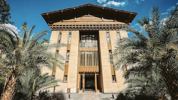 Un bâtiment à la façade symétrique, doté de grandes fenêtres et d’une entrée centrale.