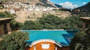 A pool with a view of a mountainous town. - LUX Tea Horse Road Deqin Benzilan (Chuxiong Yi)