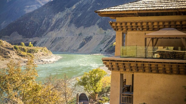 A building with a terrace overlooking a river and mountains. - LUX Tea Horse Road Deqin Benzilan (Chuxiong Yi)