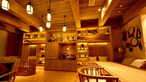 A wooden interior with a long dining table, multiple chairs, and shelves with various items. - LUX Tea Horse Road Deqin Benzilan (Chuxiong Yi)