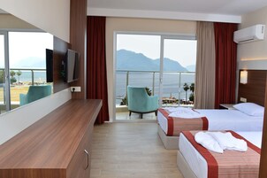Ένα δωμάτιο ξενοδοχείου με μπαλκόνι, τηλεόραση, δύο κρεβάτια και ένα γραφείο.