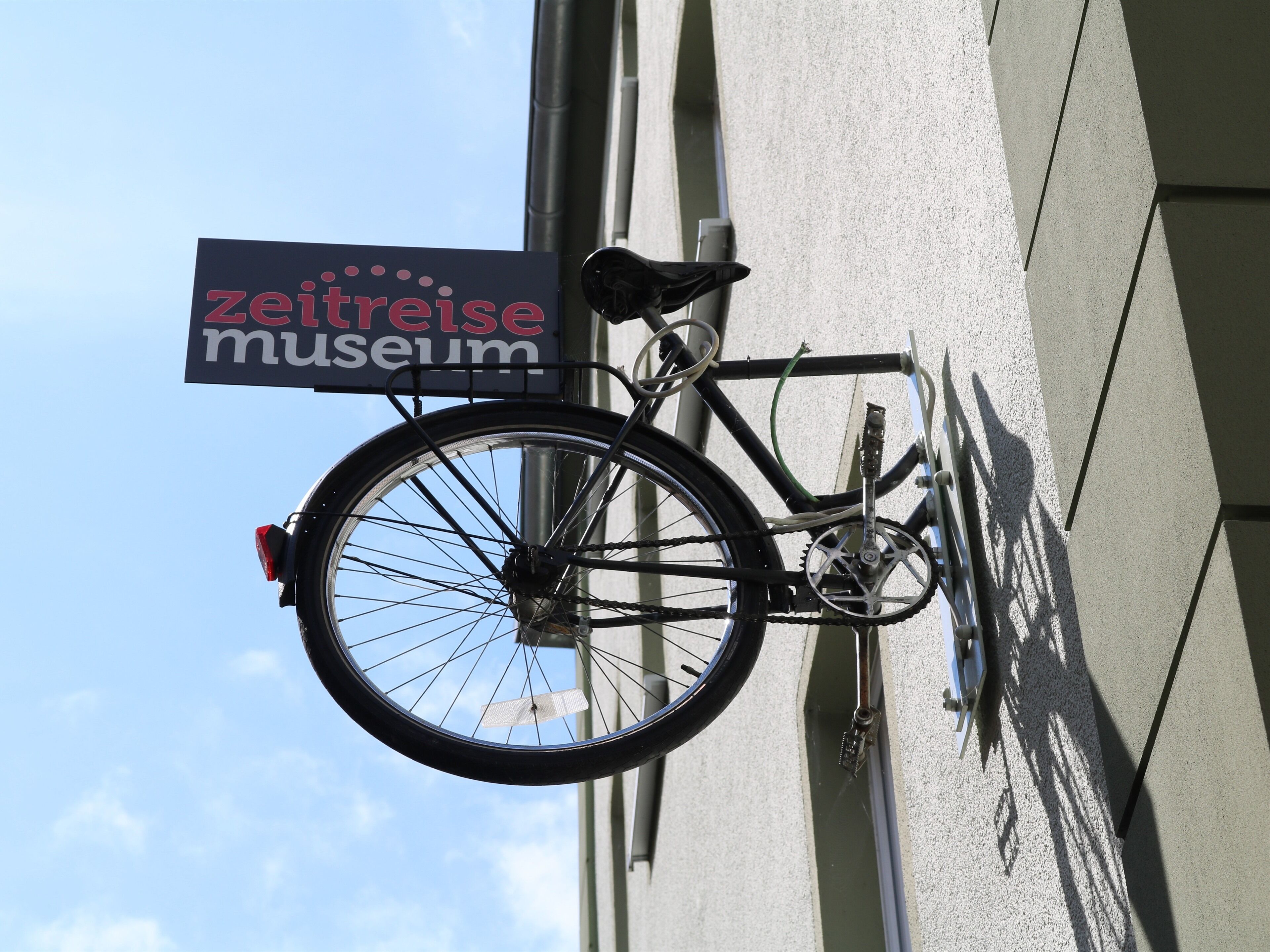 Una bicicleta estacionada frente a un edificio con un letrero que dice 'zeitreise museum'.