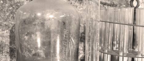 A laboratory setup with a clear glass bottle, a graduated cylinder, and a rack of test tubes.