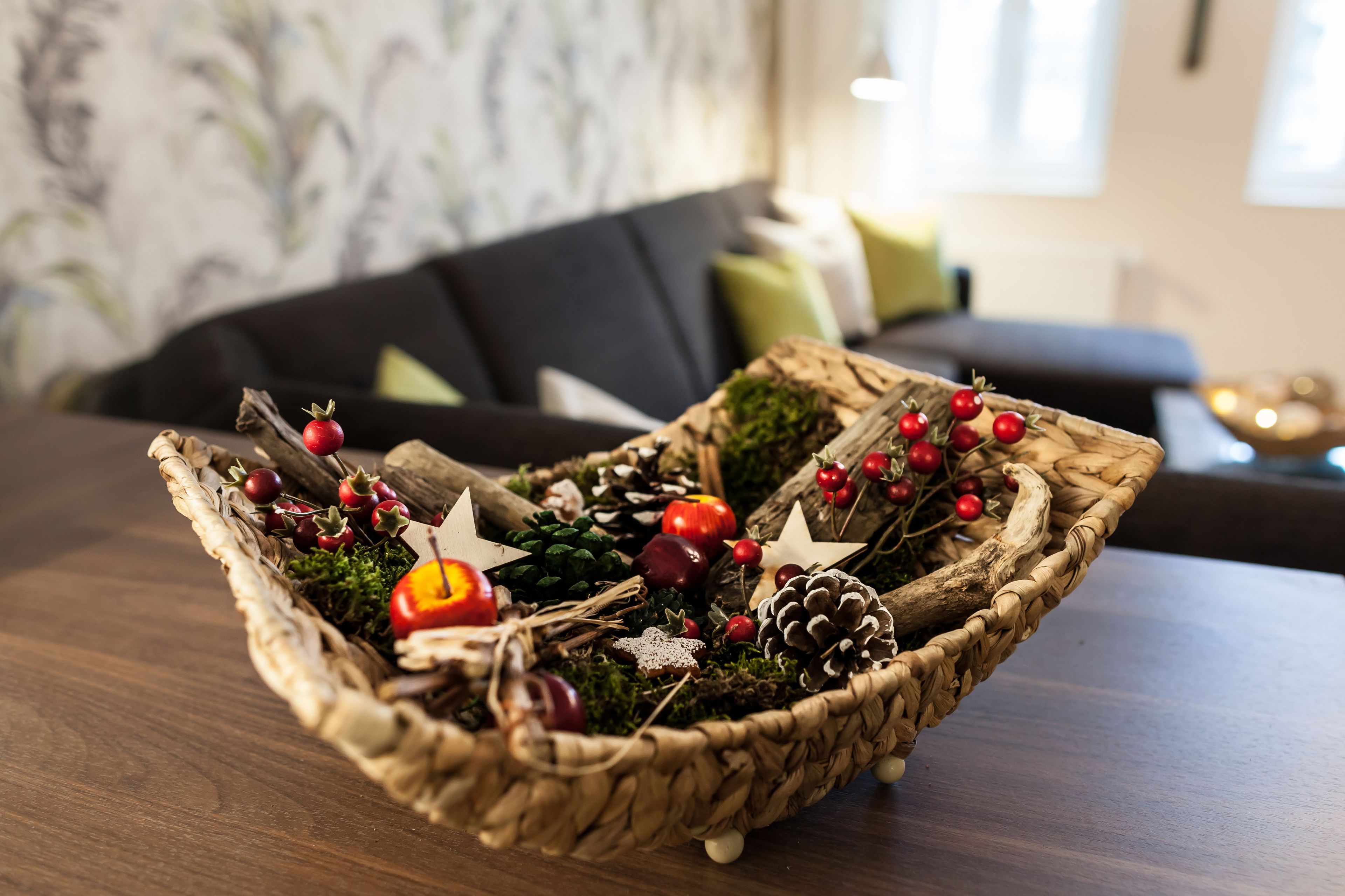 A woven basket filled with decorative items on a wooden table.