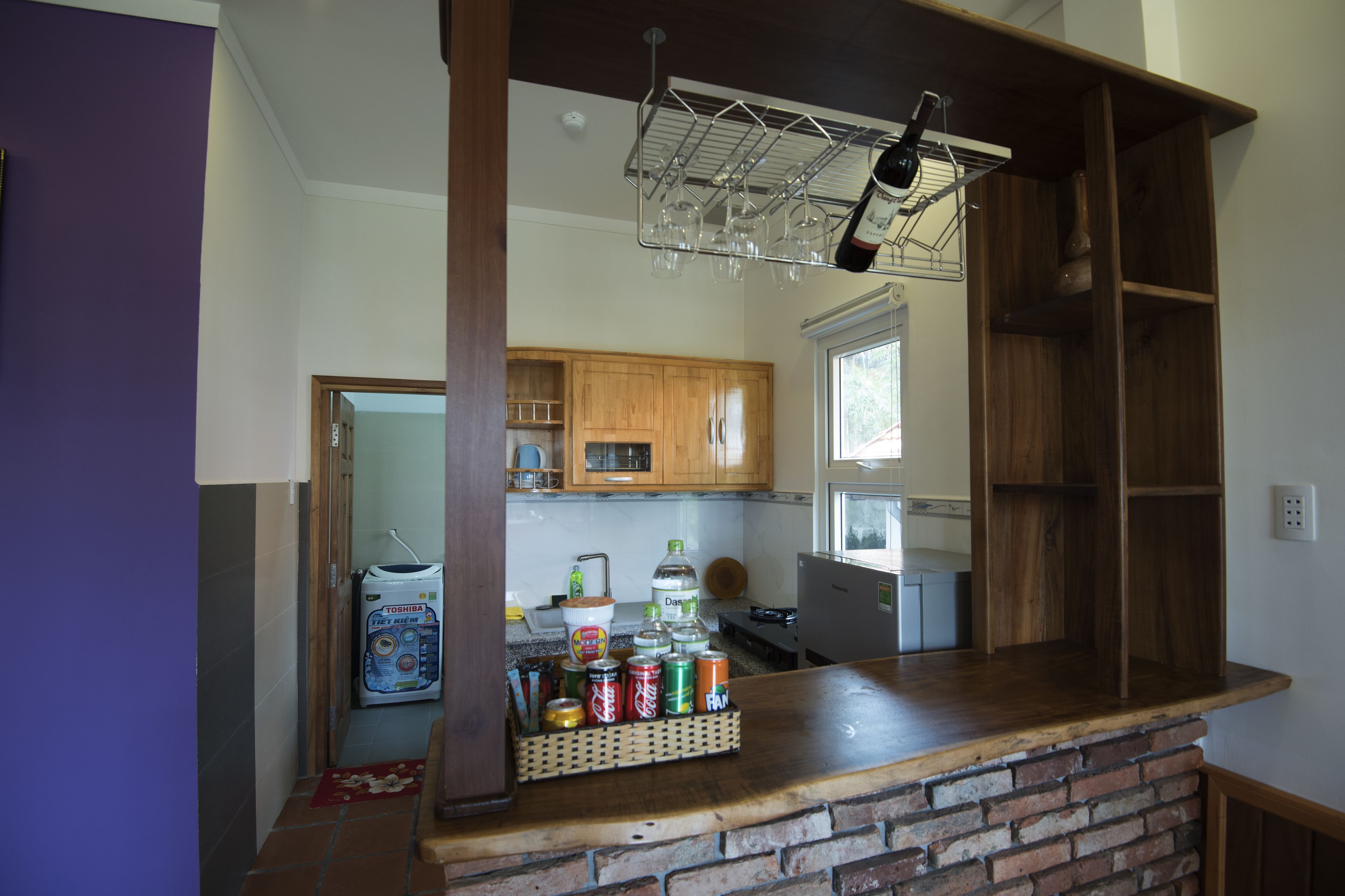 A kitchen with wooden cabinets, a brick counter, and a wine rack.