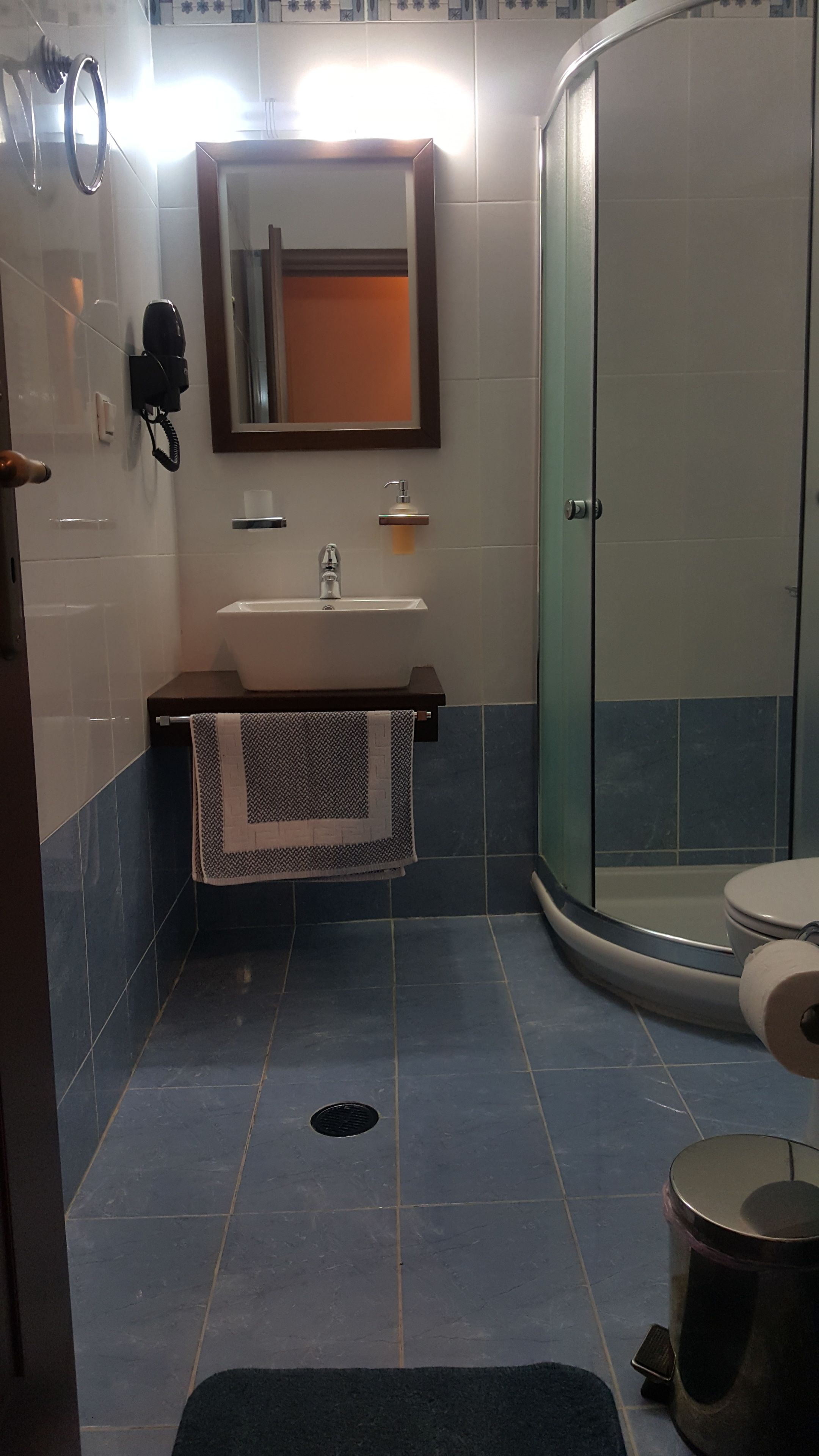 A bathroom with a toilet, sink, and shower area.