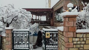 Puerta de entrada cubierta de nieve con un muro de ladrillo y un cartel que indica servicios de spa.