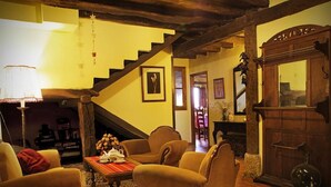 A cozy living room with a wooden staircase, comfortable seating, and a traditional wooden cabinet. - El Cajigal De Quintana (Espinosa de los Monteros)