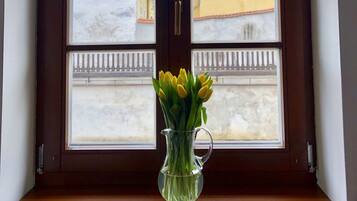 Una ventana con vista despejada a un edificio amarillo y una valla blanca.