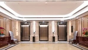 A spacious lobby with a marble floor, two reception desks, and three elevators. - Mehood Lestie Hotel Panyu Branch (Guangzhou)