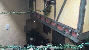 An indoor dining area with tables set for guests, a staircase, and a mural on the wall.