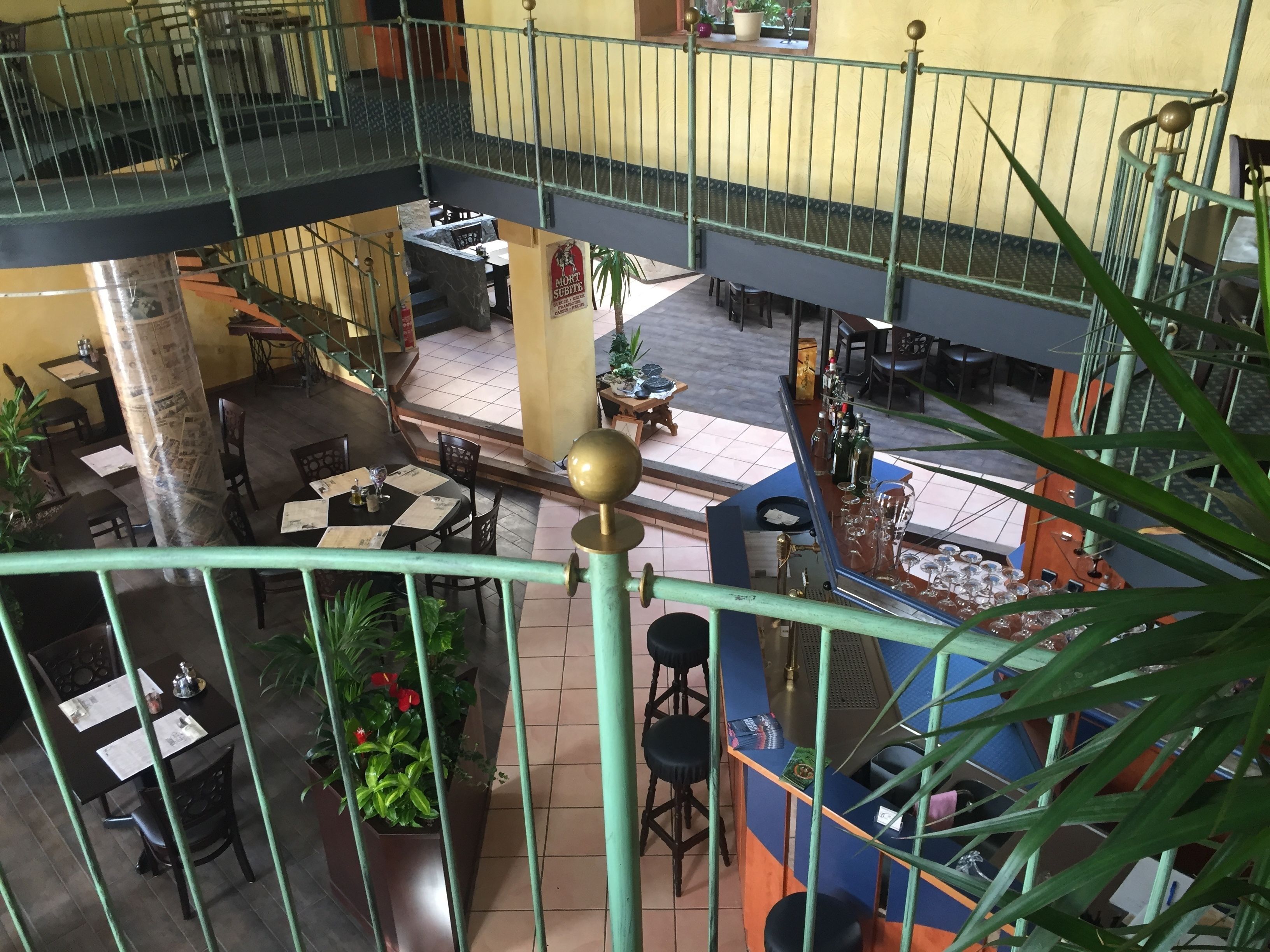 Un restaurant à plusieurs niveaux, doté d’une terrasse, d’un bar et d’un escalier reliant les différents étages.
