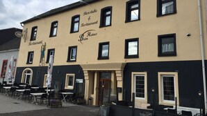 A building with the sign "Bierstube Restaurant Beimes" and outdoor seating with tables and chairs. - Beim Heines (Daun)
